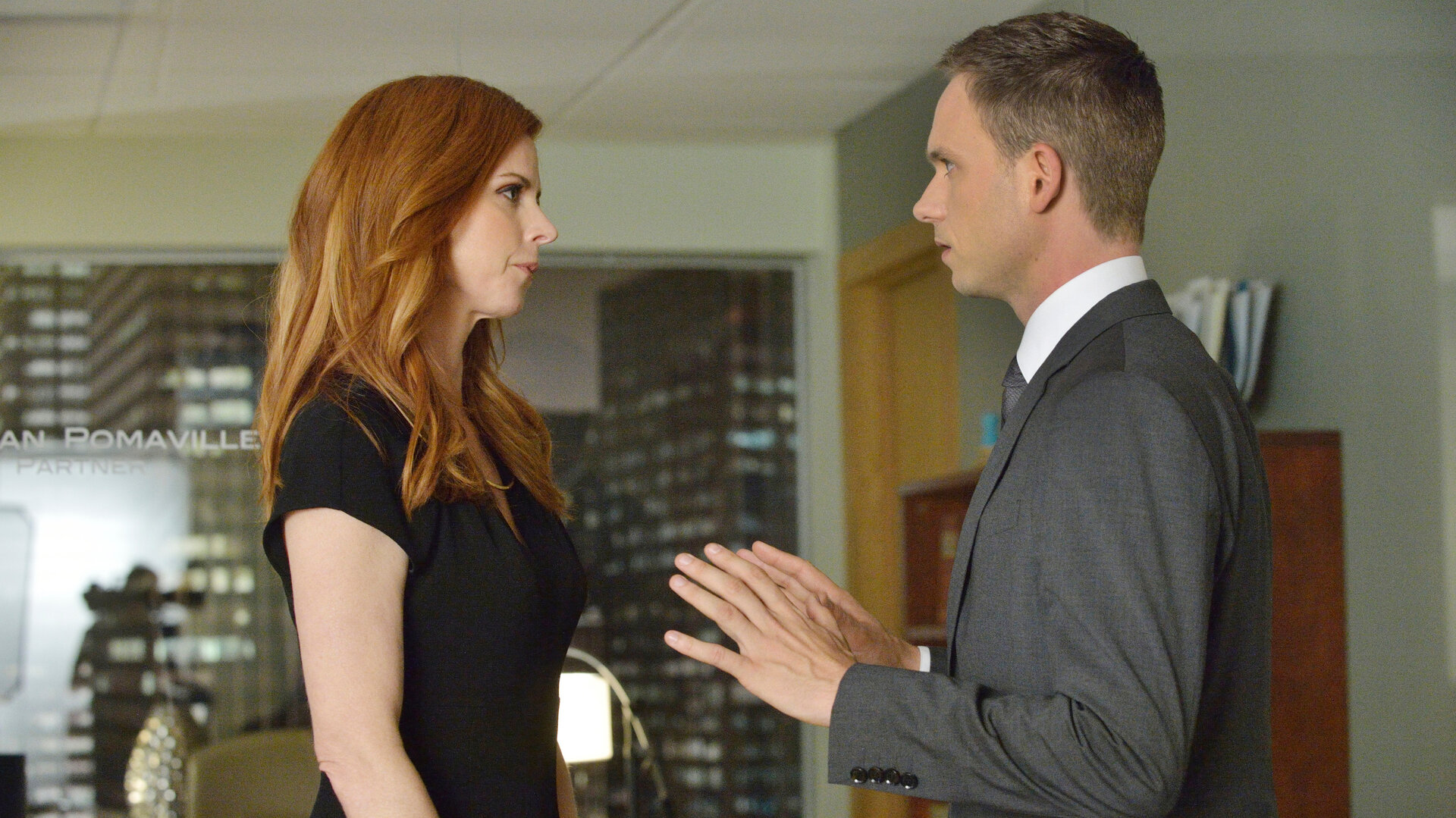"Suits - Reviermarkierung": Donna (Sarah Rafferty) und Mike (Patrick J. Adams) stehen sich in einem Büro gegenüber. Beide blicken sich ernst an, während Mike beschwichtigend die Hände hebt.