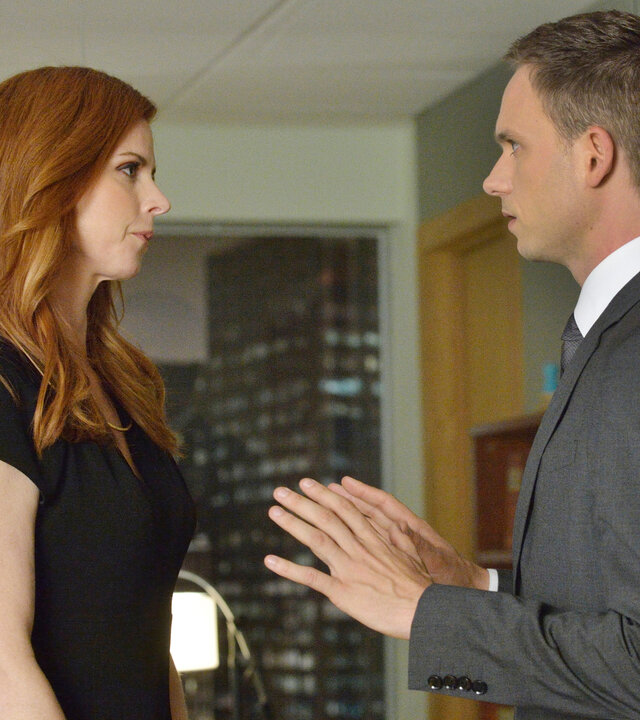 "Suits - Reviermarkierung": Donna (Sarah Rafferty) und Mike (Patrick J. Adams) stehen sich in einem Büro gegenüber. Beide blicken sich ernst an, während Mike beschwichtigend die Hände hebt.