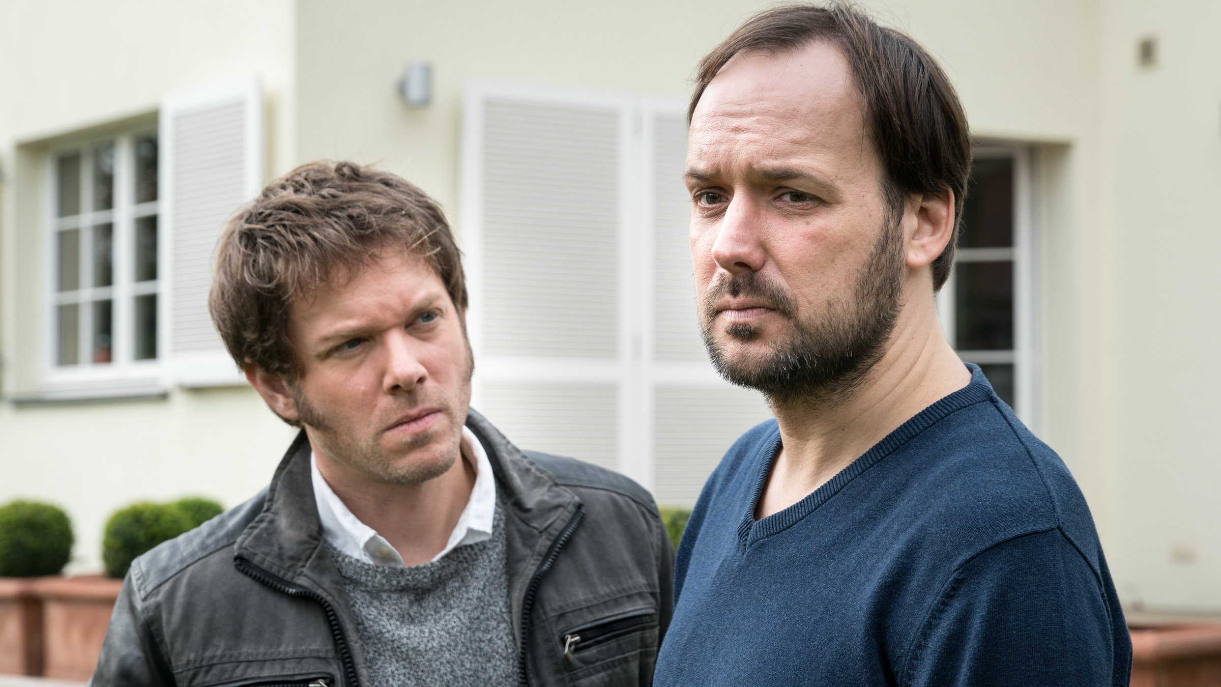 "SOKO Leipzig - Vermisstes Kind": Tom Kowalski (Steffen Schroeder) mit Henry Walser (Felix Knopp) vor einem Haus im Vorgarten.