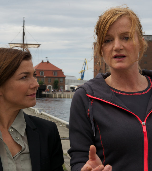 "SOKO Wismar - Meine beste Freundin": Ermittlerin Katrin Börensen (Claudia Schmutzler) läuft neben der Münchener Staatsanwältin Silvia Vandenberg (Nina Petri) her und hört ihr aufmerksam zu. Im Hintergrund ist der Hafen von Wismar zu sehen.