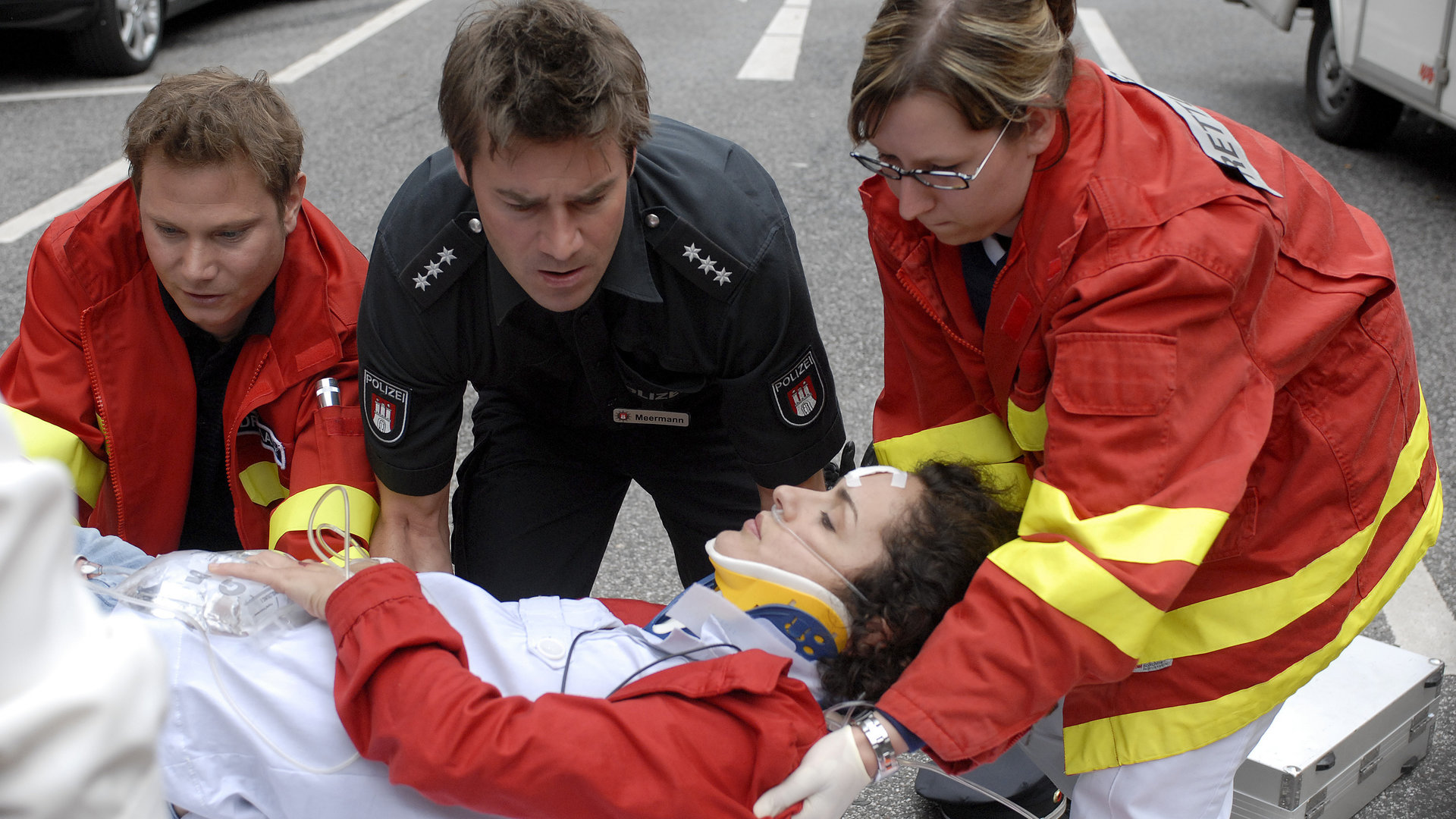 "Notruf Hafenkante - Auf Leben und Tod": Notarzt Dr. Haase (Fabian Harloff) und eine Rettungssanitäterin versorgen Anna (Marie-Lou Sellem) am Unfallort. Nils (Thomas Scharff) kniet daneben und sieht erschüttert aus.