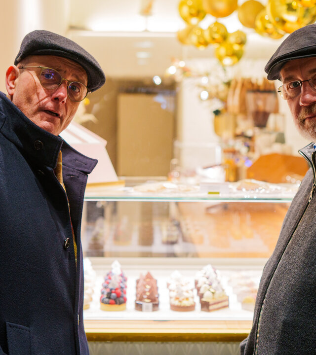 "Lesch sieht Schwartz - Versuchung: Fluch oder Segen?": Thomas Schwartz und Harald Lesch stehen vor einer Kuchentheke und schauen in die Kamera.