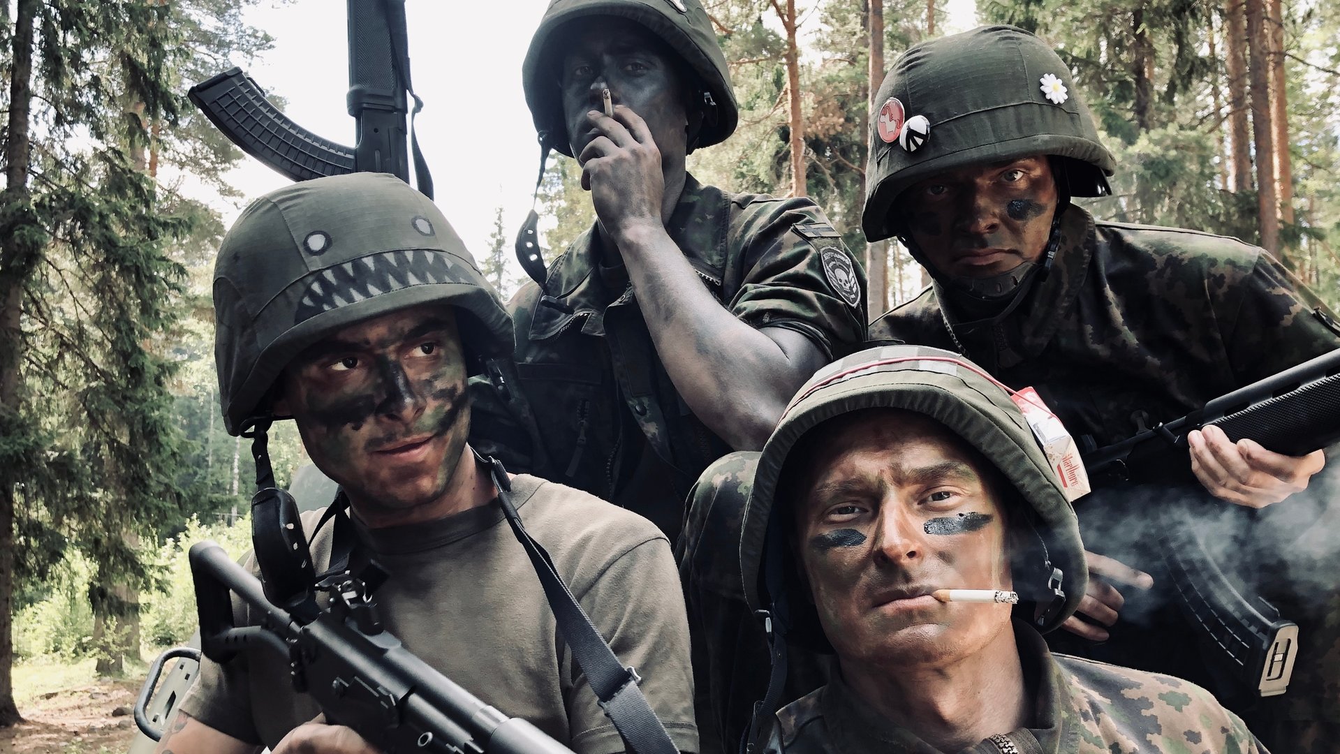 "Californian Commando - Ein Fehler": Van (Kian Lawley) sitzt mit seinen Kameraden Forsbacka (Tatu Sinisalo), Soukka (Elias Keranen) und PH (Juho Uusitalo) in Tarnklamotten in einem Wald. Dabei posieren die Soldaten mit dem Gewehr für die Kamera.