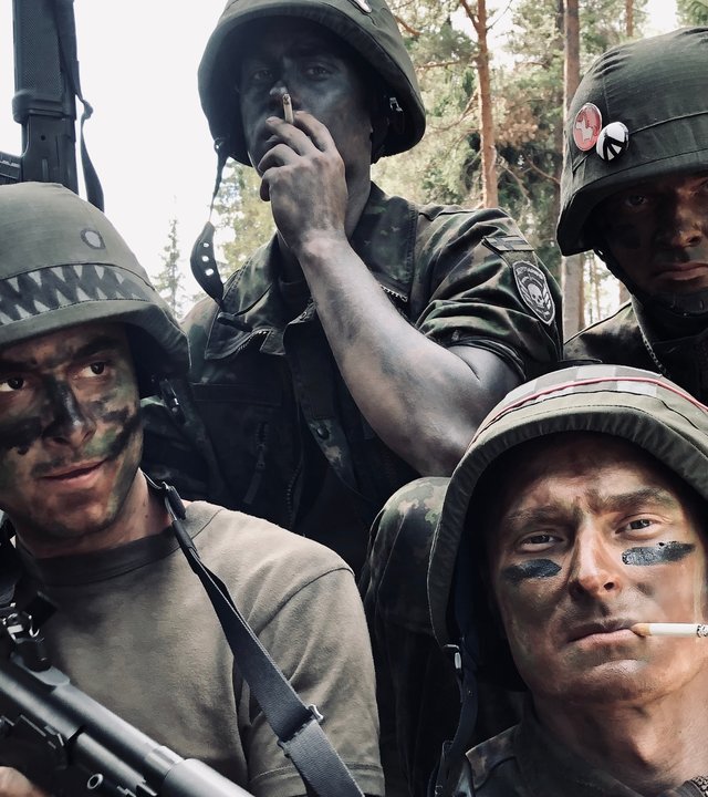 "Californian Commando - Ein Fehler": Van (Kian Lawley) sitzt mit seinen Kameraden Forsbacka (Tatu Sinisalo), Soukka (Elias Keranen) und PH (Juho Uusitalo) in Tarnklamotten in einem Wald. Dabei posieren die Soldaten mit dem Gewehr für die Kamera.
