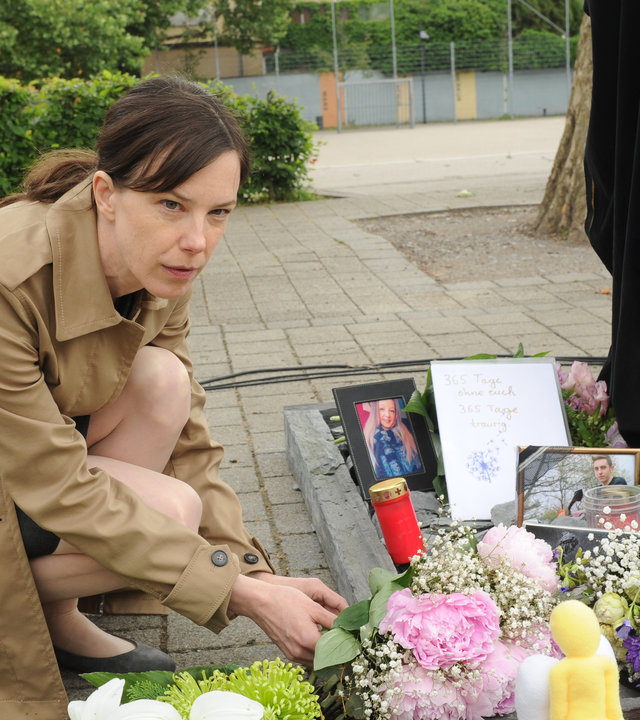 "SOKO Stuttgart - Sühne": An der Gedenkstätte für die verstorbenen Schüler legt Johanna Lehmann (Anne von Keller) einen Blumenstrauß zu den bereits vorhandenen Kerzen, Sträußen, Briefen und Bildern nieder.