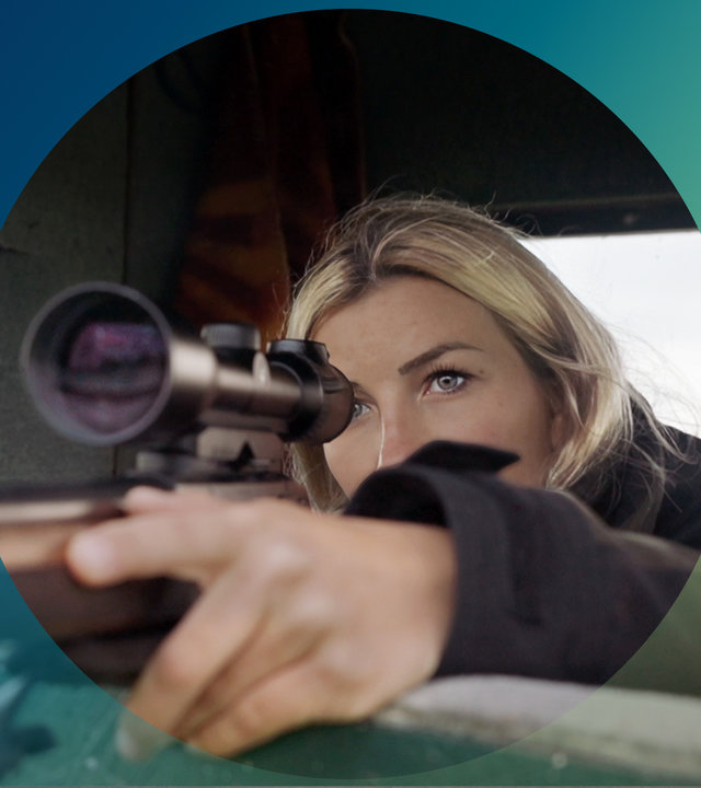 "planet e.: Jagen, shooten, posten - mit jungen Jägern unterwegs": Jagd-Influencerin Lina zielt mit ihrem Gewehr zur Seite.