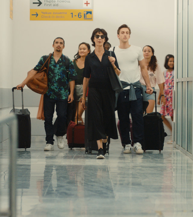 "L´Opéra - Dancing in Paris - Grand Prix": Diane (Anne Alvaro) läuft an der Spitze einer Gruppe junger Tänzer einen Korridor in einem Flughafen entlang.