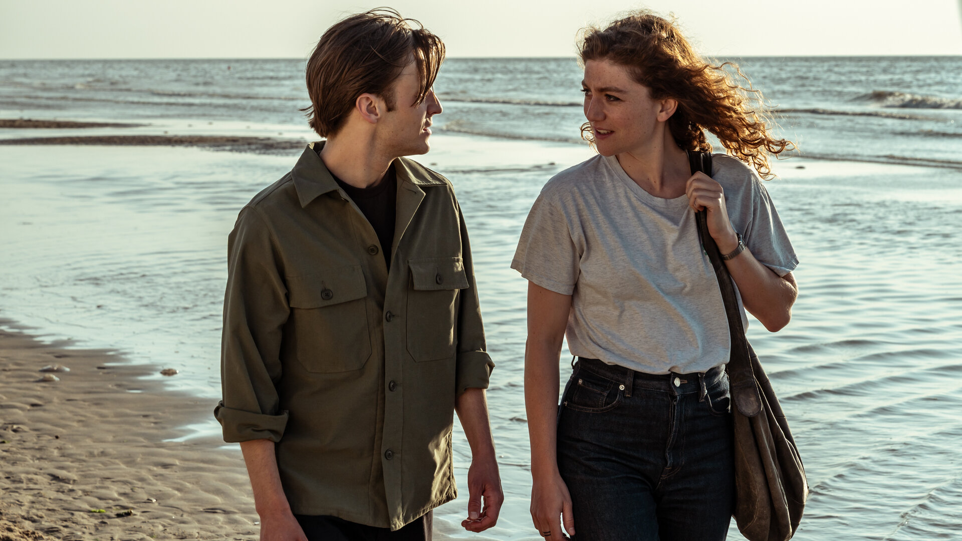 "Juliet - Blut und Wasser": Sam (Jonas Vermeulen) und Juliet (Charlotte De Bruyne) laufen einander zugewandt am Meer entlang.