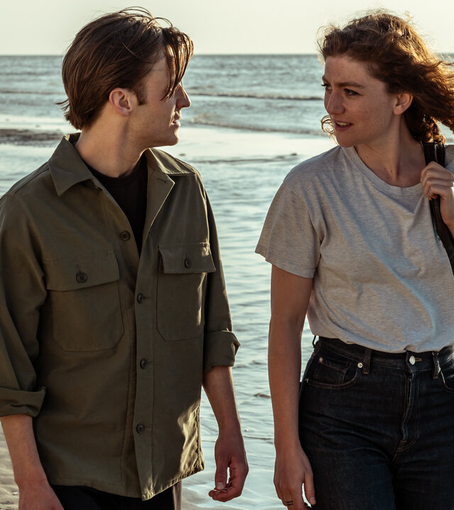 "Juliet - Blut und Wasser": Sam (Jonas Vermeulen) und Juliet (Charlotte De Bruyne) laufen einander zugewandt am Meer entlang.