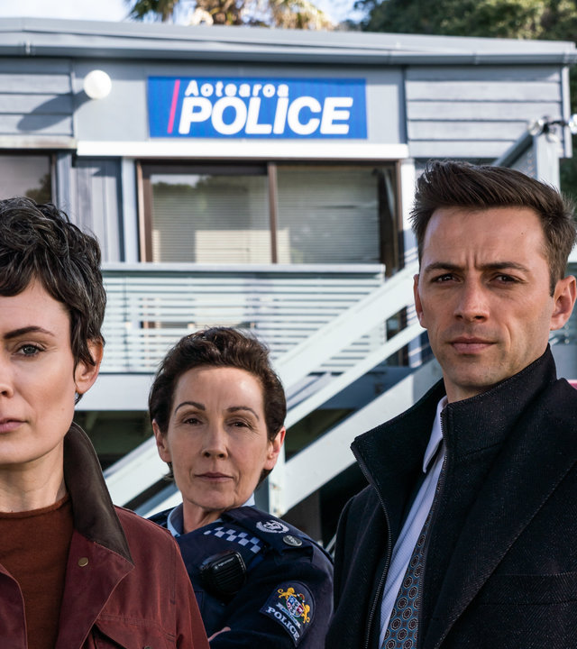 "Auckland Detectives - Tödliche Bucht: Enttarnung": Detective Senior Sergeant Jessica Savage (Kate Elliott), ihr Kollege Detective Sergeant Justin Harding (Ido Drent) und Senior Sergeant Denise Abernethy (Alison Bruce) stehen in Nahaufnahme vor der Polizeistation in Waiheke.