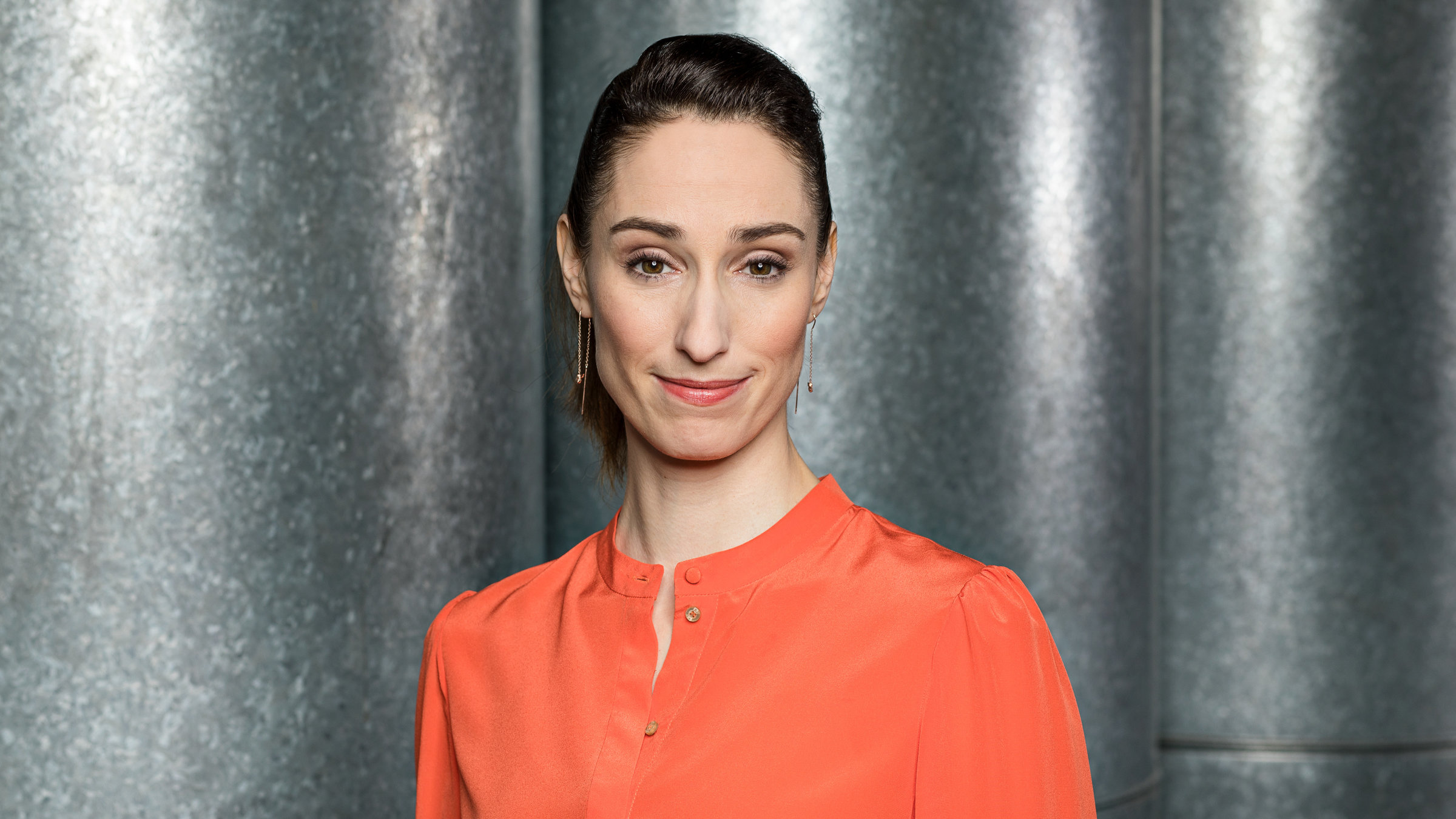 "Der 3satThema Talk": Porträtbilder von Vivian Perkovic (nur Oberkörper). Sie trägt eine apricotfarbene Bluse und schaut in die Kamera.