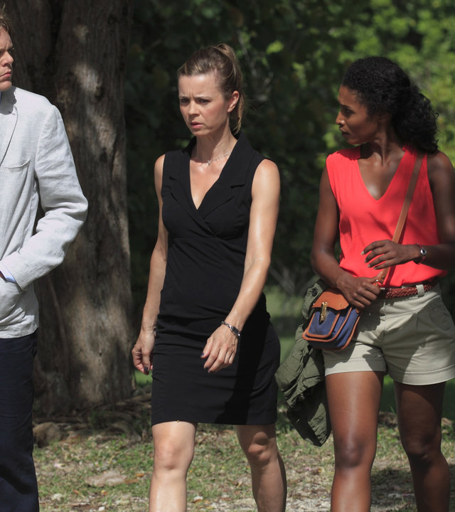 "Death in Paradise - Der Sturm": Humphrey (Kris Marshall), Camille (Sara Martins) und Emily (Caroline Proust) laufen nebeneinander durch einen Wald und unterhalten sich.