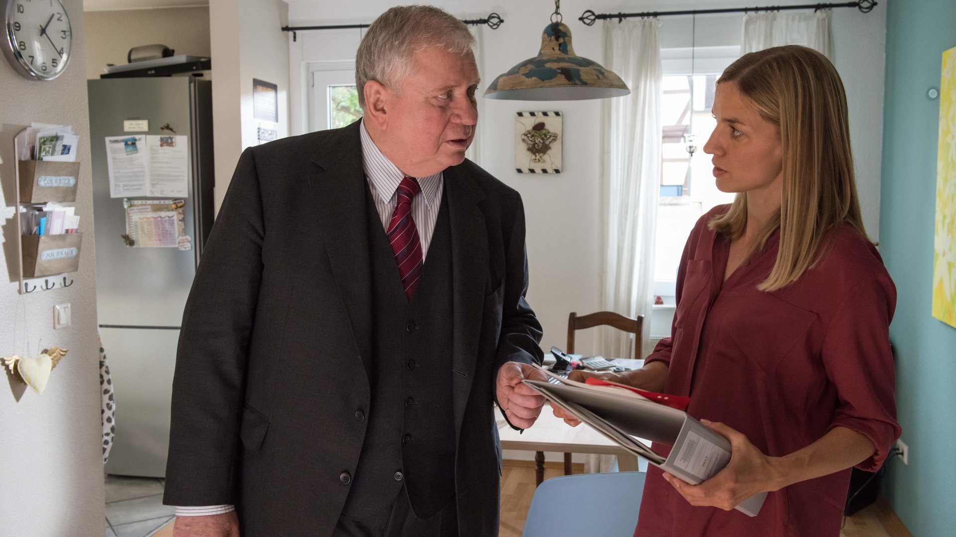 "Der Staatsanwalt – Taunushexe": Bernd Reuther (Rainer Hunold) und Eva Kastner (Annika Blendl) stehen sich in einer Küche gegenüber und unterhalten sich. Eva hat einen Ordner in der Hand.