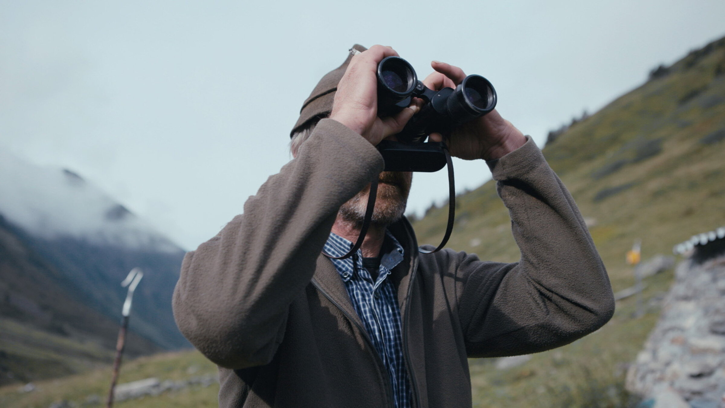 "Der Wolf im Visier – Schutz oder Abschuss?": Mann mit Fernglas.