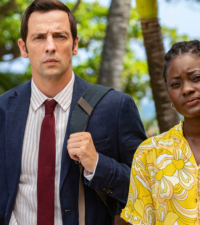 "Death in Paradise - Feuer im Herzen": Detective Neville Parker (Ralf Little) und Naomi Thomas (Shantol Jackson) stehen Seite an Seite und starren geradeaus.