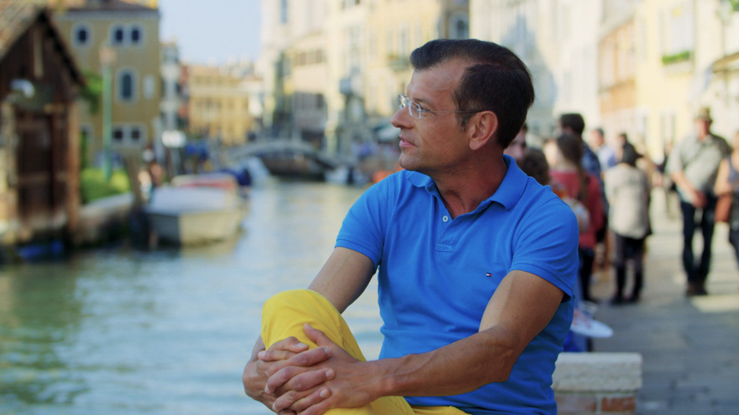 "Die geheimen Gärten von Venedig": Karl Ploberger sitzt auf einer Mauer am Wasser in Venedig.