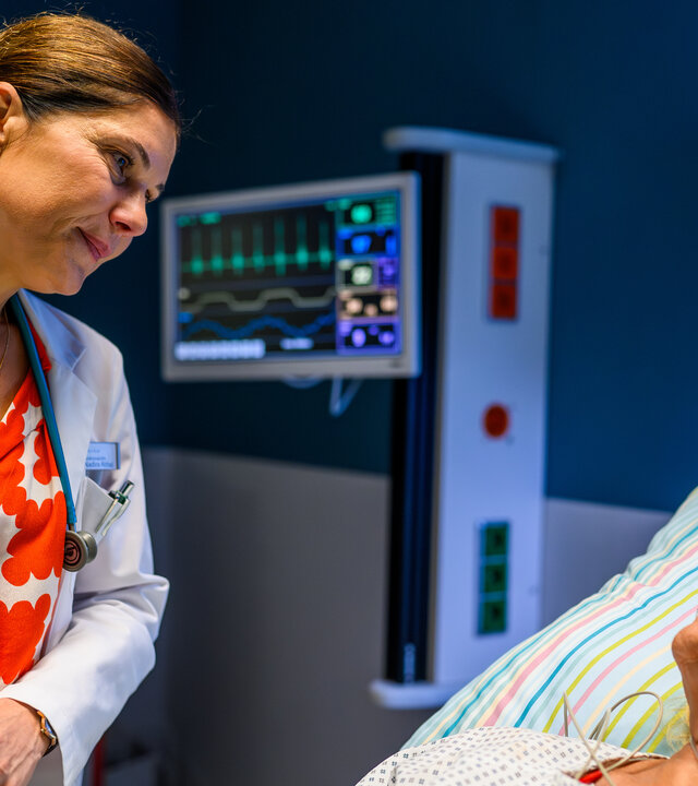 "Bettys Diagnose - Prioritäten": Dr. Nadira Abbas (Yasmina Djaballah) steht im Krankenzimmer am Bett ihrer Mutter Ines Abbas (Claudia Rieschel) und hält deren Hand. Sie schauen sich beide an.