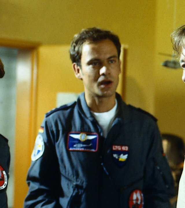 "Die Rettungsflieger- Was lange gärt...": Notärztin Maren (Gerit Kling) und ihr Kollege Alex (Matthias Leja) stehen auf einem Flur neben Dr. Bernard Maibach (Ulrich Wiggers). Maren sieht Maibach mit großen Augen an, Alex spricht auf ihn ein.