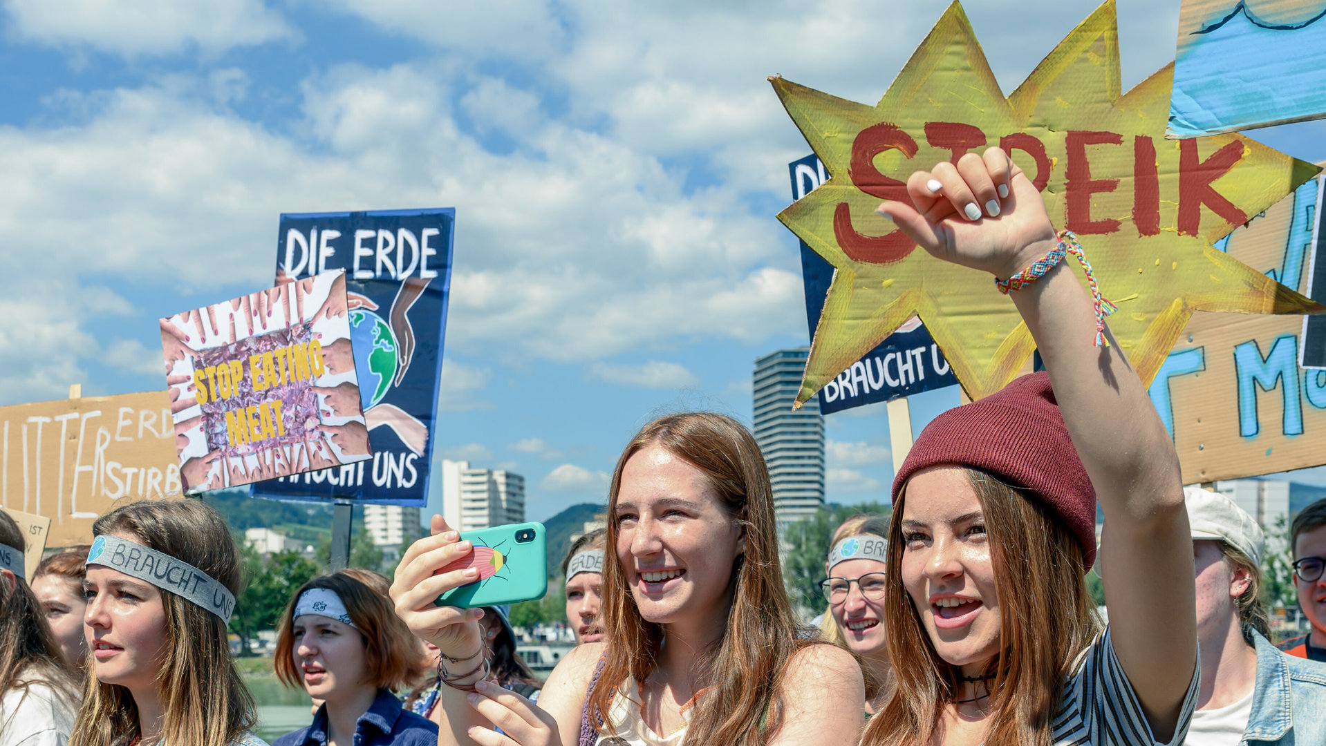 "SOKO Linz - Die Erde braucht uns": Emilia Halberg (Paula Hainberger) steht mit erhobener Faust in einer Menge von Mädchen und Jungen ihres Alters. Sie jubelt, die anderen halten Schilder eines Klimaprotestes in die Höhe.