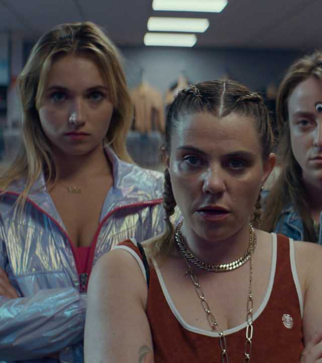 "Derby Girl - Stich ins Wespennest": MJ (Salomé Diénis Meulien), Lola (Chloé Jouannet), Mother Blocker (Sophie-Marie Larrouy), Booby Mercury (Allison Chassagne) und Absinthe (Suzanne De Baecque) stehen nebeneinander in einem Laden und schauen ernst nach vorne.