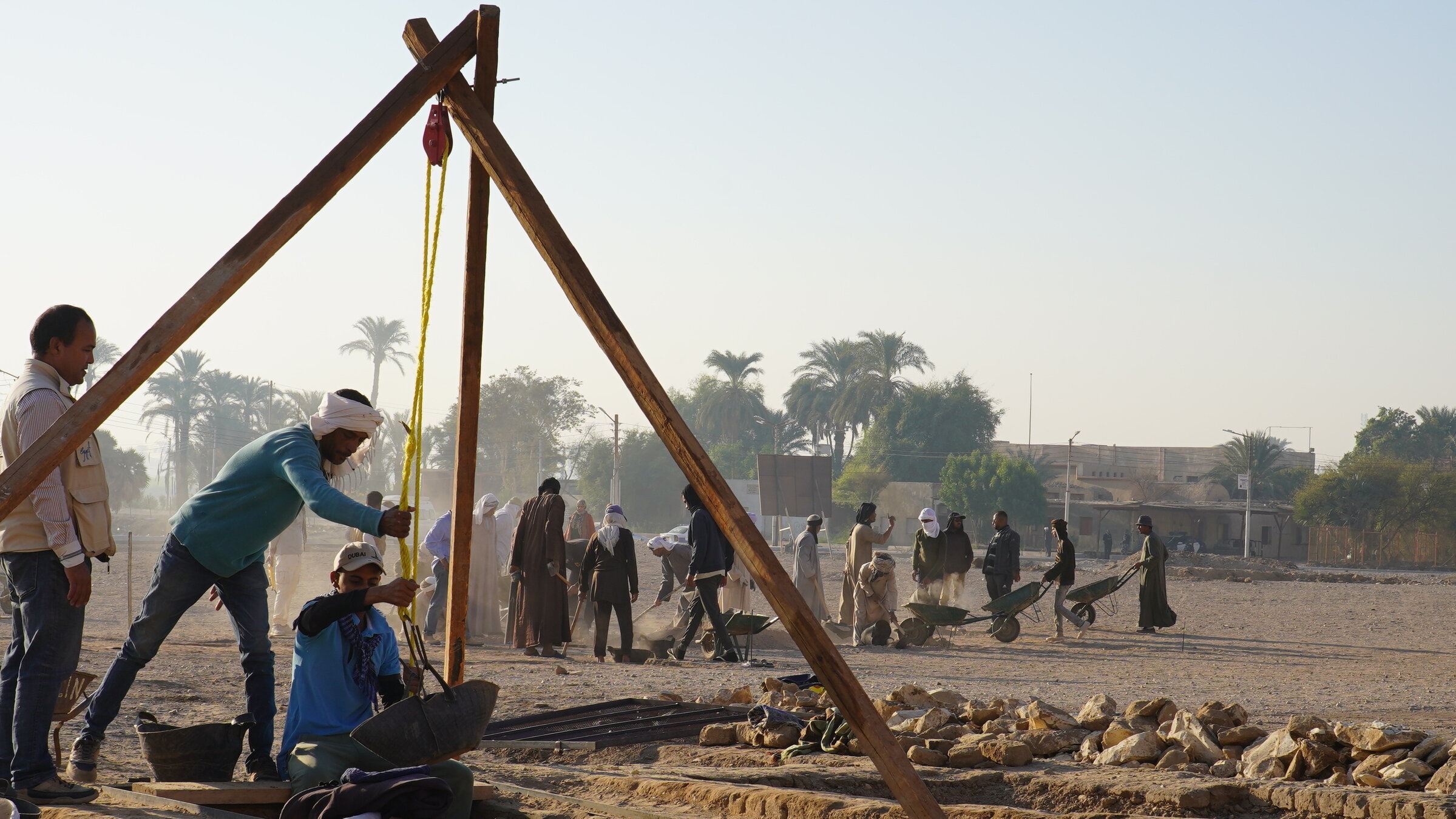 "Terra X: Ägyptens vergessene Gräber": Auf der Ausgrabungsstätte: Arbeiter leeren mit Hilfe eines einfachen Flaschenzuges einen Schacht. Im Hintergrund sind weitere Arbeiter, einige fahren Schubkarren.