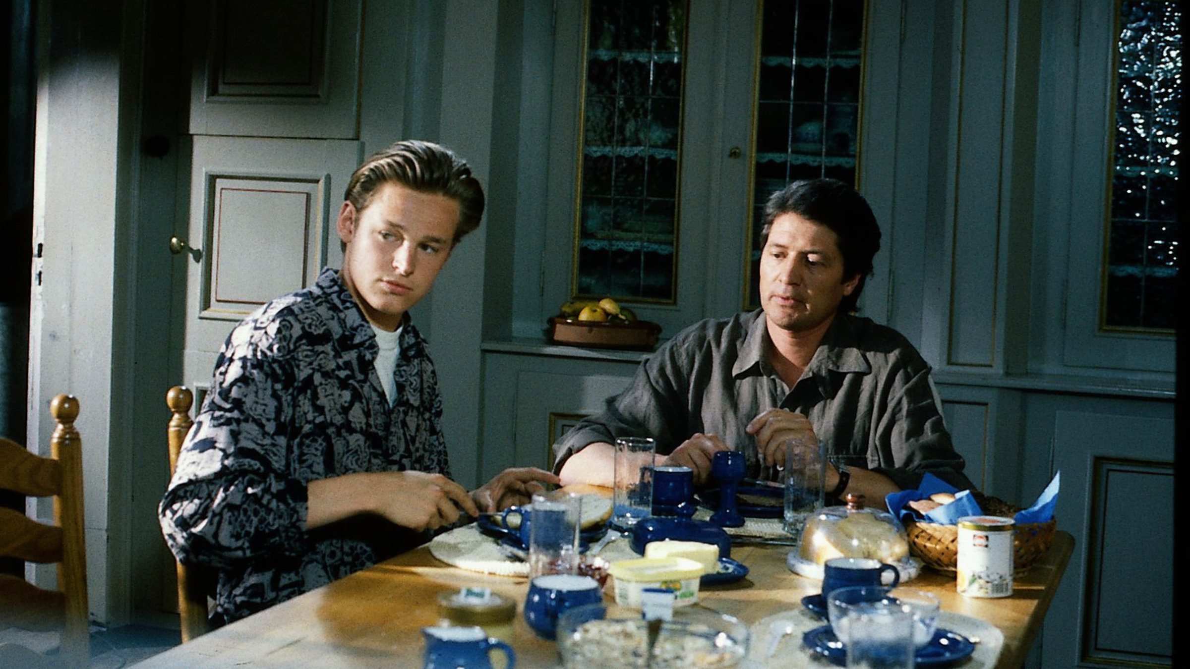 "Der Landarzt - Freitag, der 13.": Eike (Hendrik Martz) und Dr. Mattiesen (Christian Quadflieg) sitzen gemeinsam an einem gedeckten Tisch und schauen ernst in die Ferne.