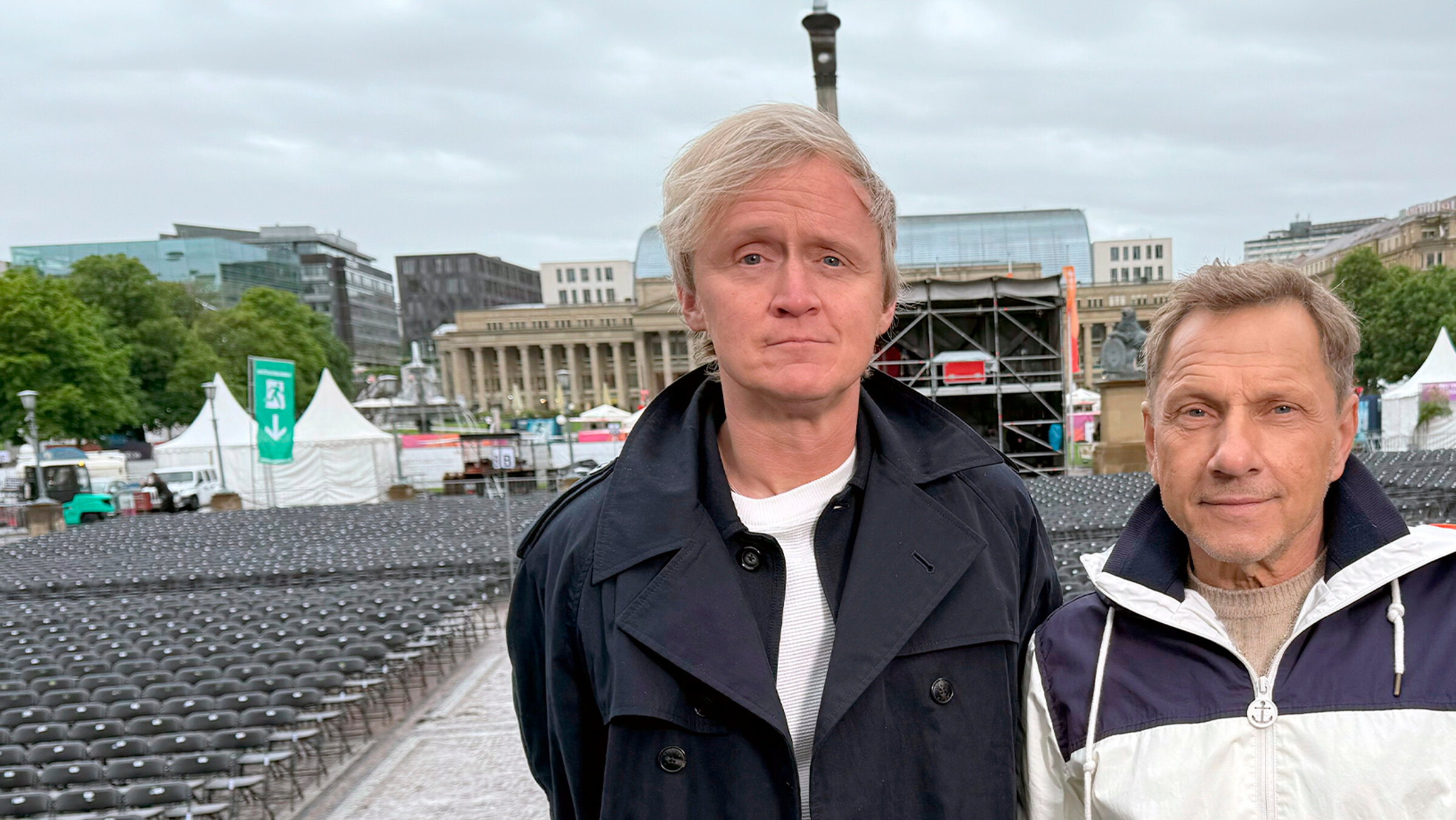 "Kurzstrecke mit Pierre M. Krause - Richy Müller wird echt gefeiert": 15 Jahre lang haben sich Pierre M. Krause (li.) und Richy Müller nicht gesehen. Fast doppelt so oft wurde Pierre explizit NICHT aufs SWR-Sommerfest eingeladen. Klar, der Name des Events erscheint im Stuttgarter Regen so kontrovers wie die Entscheidung, einen deutschen Schauspieler für einen Blockbuster nicht als Nazi zu besetzen. Aber 4.000 Zuschauer wären für Pierre nun mal doch eine neue Bestmarke. Und weil Richy gerade nicht mit Jodie Foster rolexed, bringt er ihn kurzerhand aufs Festgelände Rain, Man!