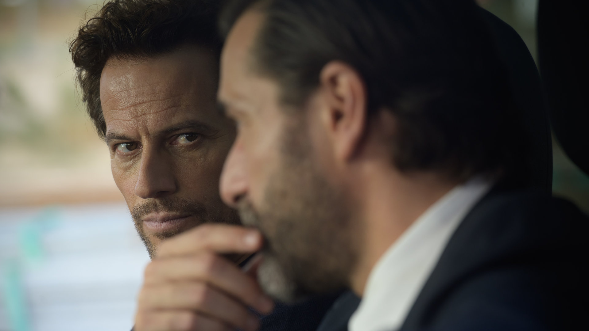 "Das Mädchen und die Nacht - Wenn die Vergangenheit dich einholt": Thomas (Ioan Gruffudd) und Max (Grégory Fitoussi) sitzen nebeneinander im Auto. Thomas blickt ernst, während Max nachdenklich einen Finger an den Mund legt.