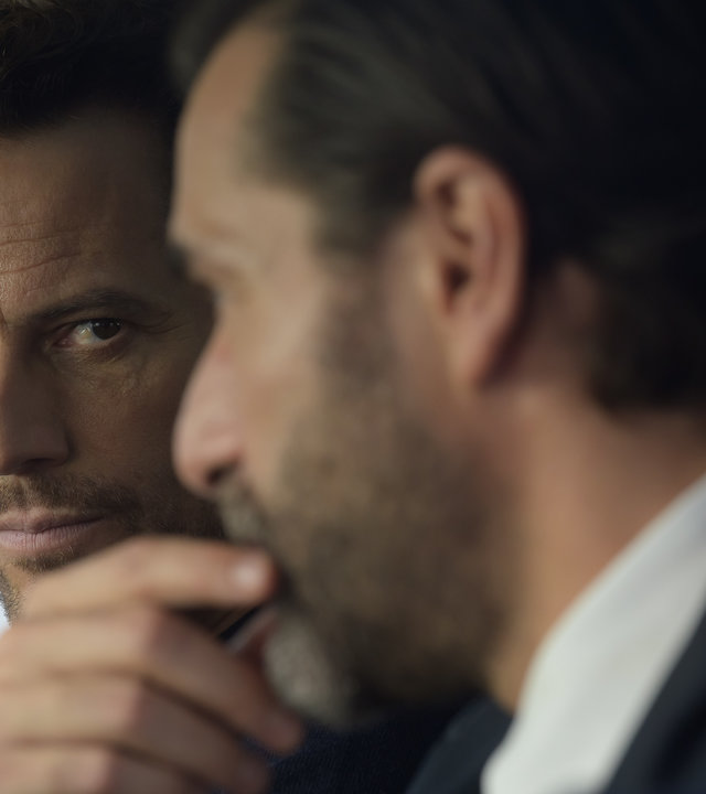 "Das Mädchen und die Nacht - Wenn die Vergangenheit dich einholt": Thomas (Ioan Gruffudd) und Max (Grégory Fitoussi) sitzen nebeneinander im Auto. Thomas blickt ernst, während Max nachdenklich einen Finger an den Mund legt.