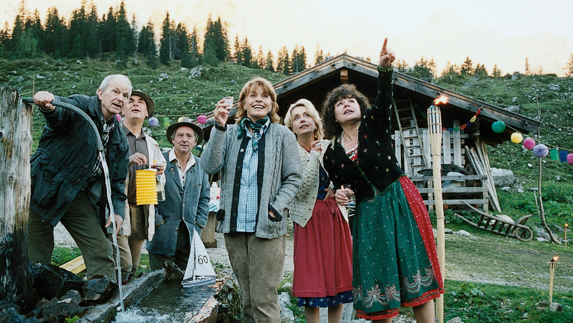 "Die schnelle Gerdi und die Hauptstadt – Hoch drob'n auf'm Berg": Vor einer Berghütte stehen Frank (Michael Gwisdek), Horst Ziegler (Johann Adam Oest), Rocco (Günter Maria Halmer), Gerdi (Senta Berger), Heidi (Gisela Schneeberger) und Monika (Gundi Ellert) gemeinsam auf einer Alm.