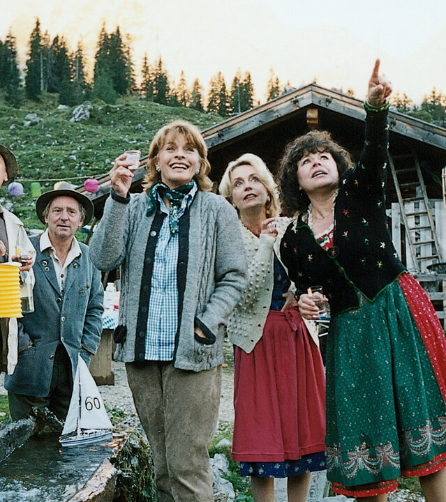 "Die schnelle Gerdi und die Hauptstadt – Hoch drob'n auf'm Berg": Vor einer Berghütte stehen Frank (Michael Gwisdek), Horst Ziegler (Johann Adam Oest), Rocco (Günter Maria Halmer), Gerdi (Senta Berger), Heidi (Gisela Schneeberger) und Monika (Gundi Ellert) gemeinsam auf einer Alm.