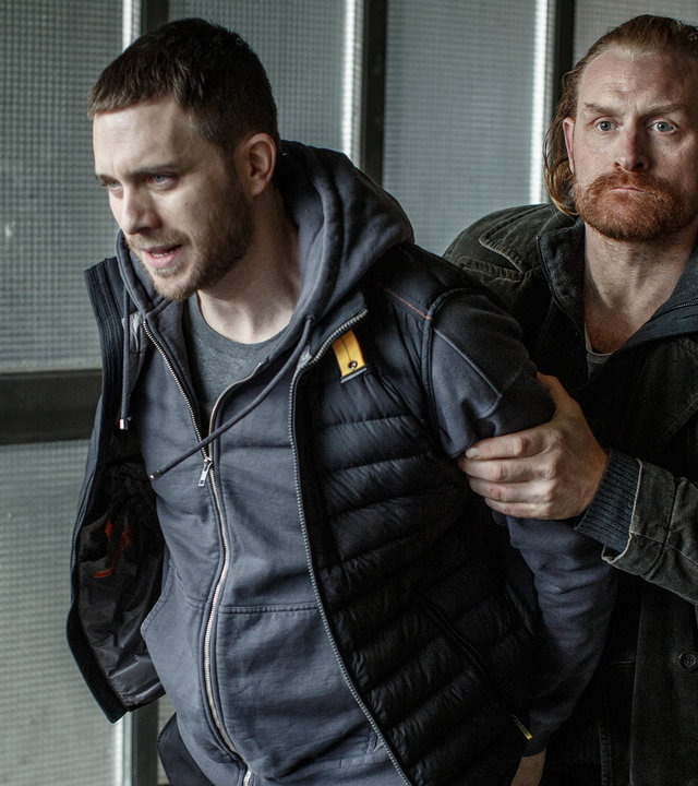 "Kommissar Beck: Undercover": Mit seinen Händen hinter dem Rücken wird Josef Eriksson (Martin Wallström) von einem entschlossen dreinblickenden Steinar Hovland (Kristofer Hivju) abgeführt.