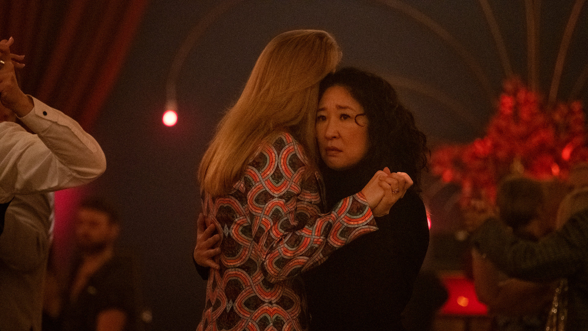 "Killing Eve - Tanztee": Villanelle (Jodie Comer) und Eve (Sandra Oh) tanzen eng miteinander inmitten anderer Leute auf einer Tanzfläche.