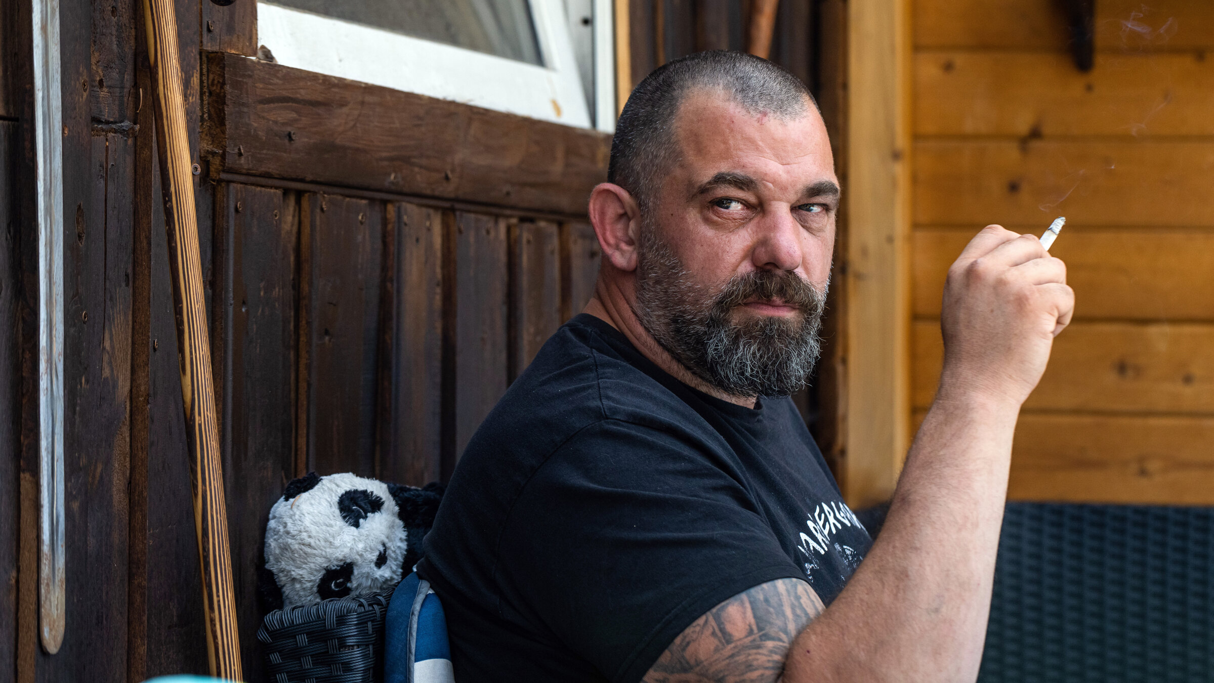 "Im Kopf geht der Krieg weiter - Überleben nach dem Einsatz": Martin sitzt draußen auf einer Bank und hält eine Zigarette in der Hand.