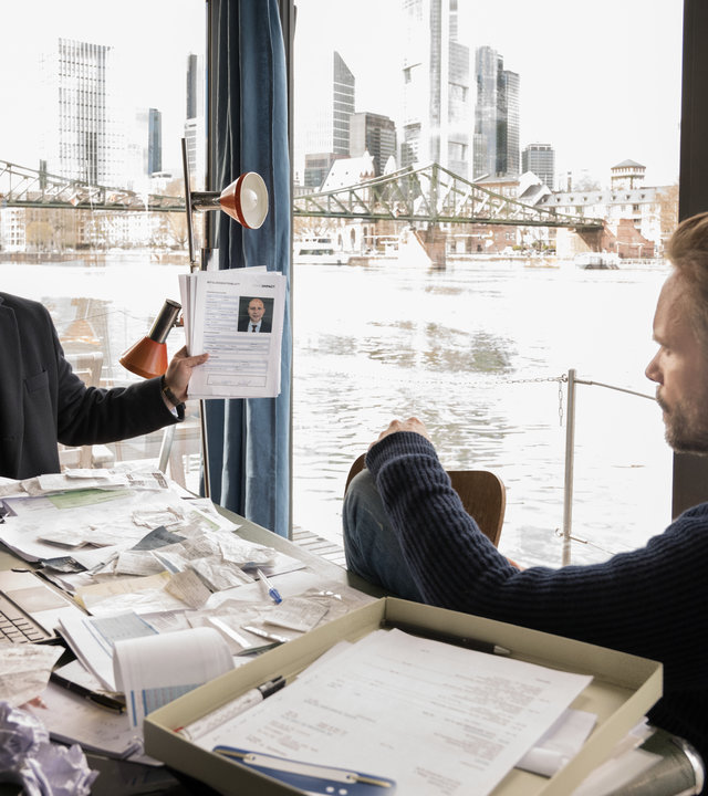 "Ein Fall für zwei - Kanalratten": Benni Hornberg (Antoine Monot, Jr.) und Leo Oswald (Wanja Mues) sitzen im Hausboot und sprechen mit einander. Benni zeigt dabei Leo eine Akte.
