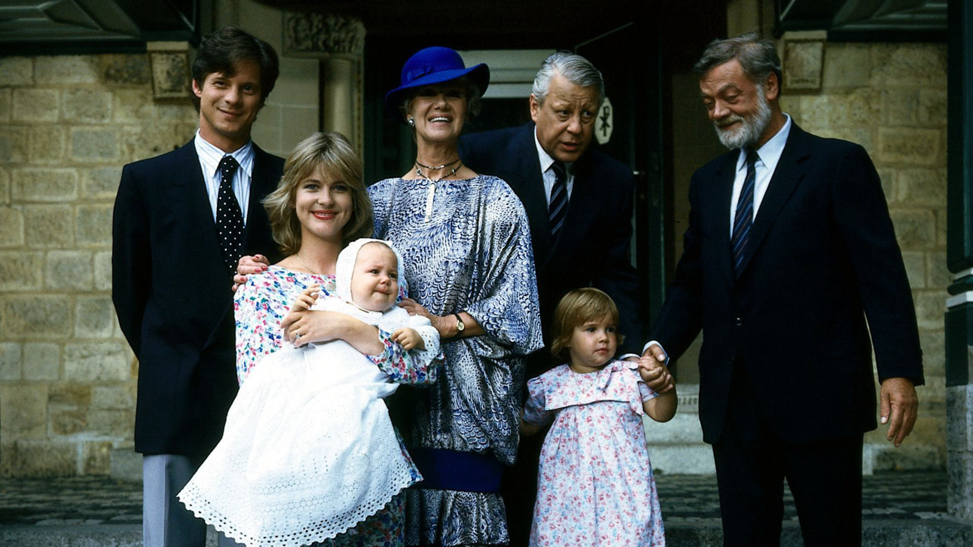"Die Wicherts von nebenan: Die Anhalterin": Rüdiger (Jochen Schroeder), Uschi (Anja Schüte), Hannelore (Maria Sebaldt), Eberhard (Stephan Orlac) und Graf von Strelenau (Friedrich Schütter) stehen mit den Kindern auf der Treppe vor einer Kirche und posieren für eine Foto.