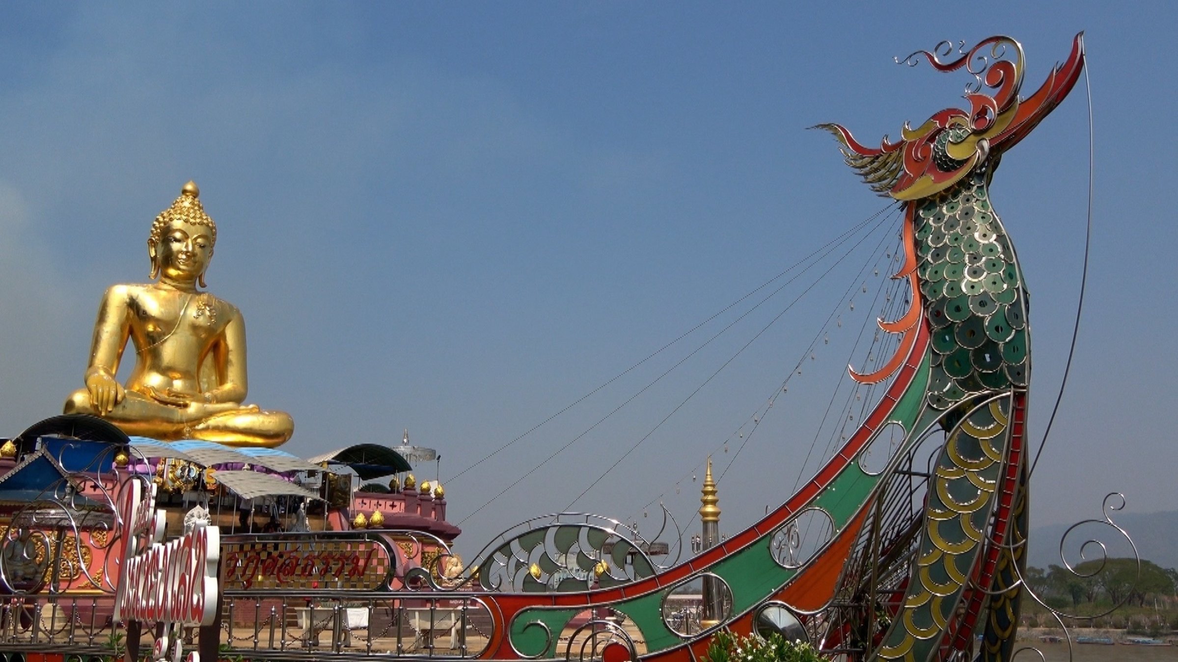 "Thailand - Unterwegs im Königreich des Lächelns": Teilaufnahme einer schiffsähnlichen Struktur, auf der eine große goldene Buddha-Figur sitzt.