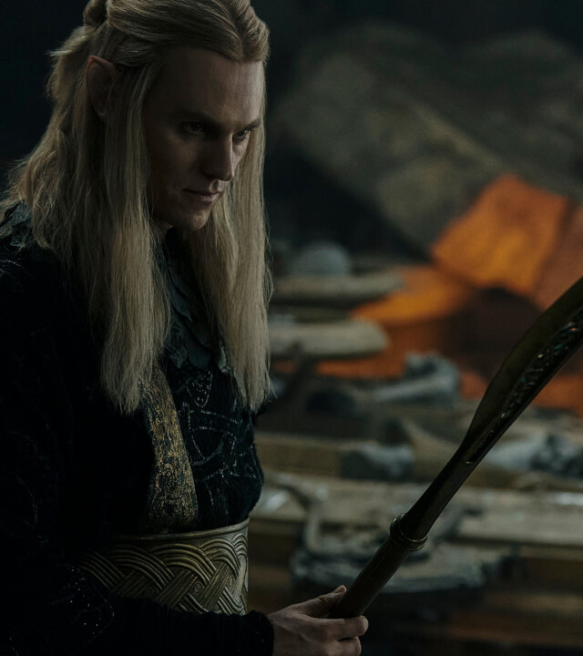 "Der Herr der Ringe: Die Ringe der Macht - Schatten und Flammen": Sauron (Charlie Vickers) steht in einem Raum, in dem Gegenstände verstreut herumliegen. Er hält ein Schwert in der Hand.