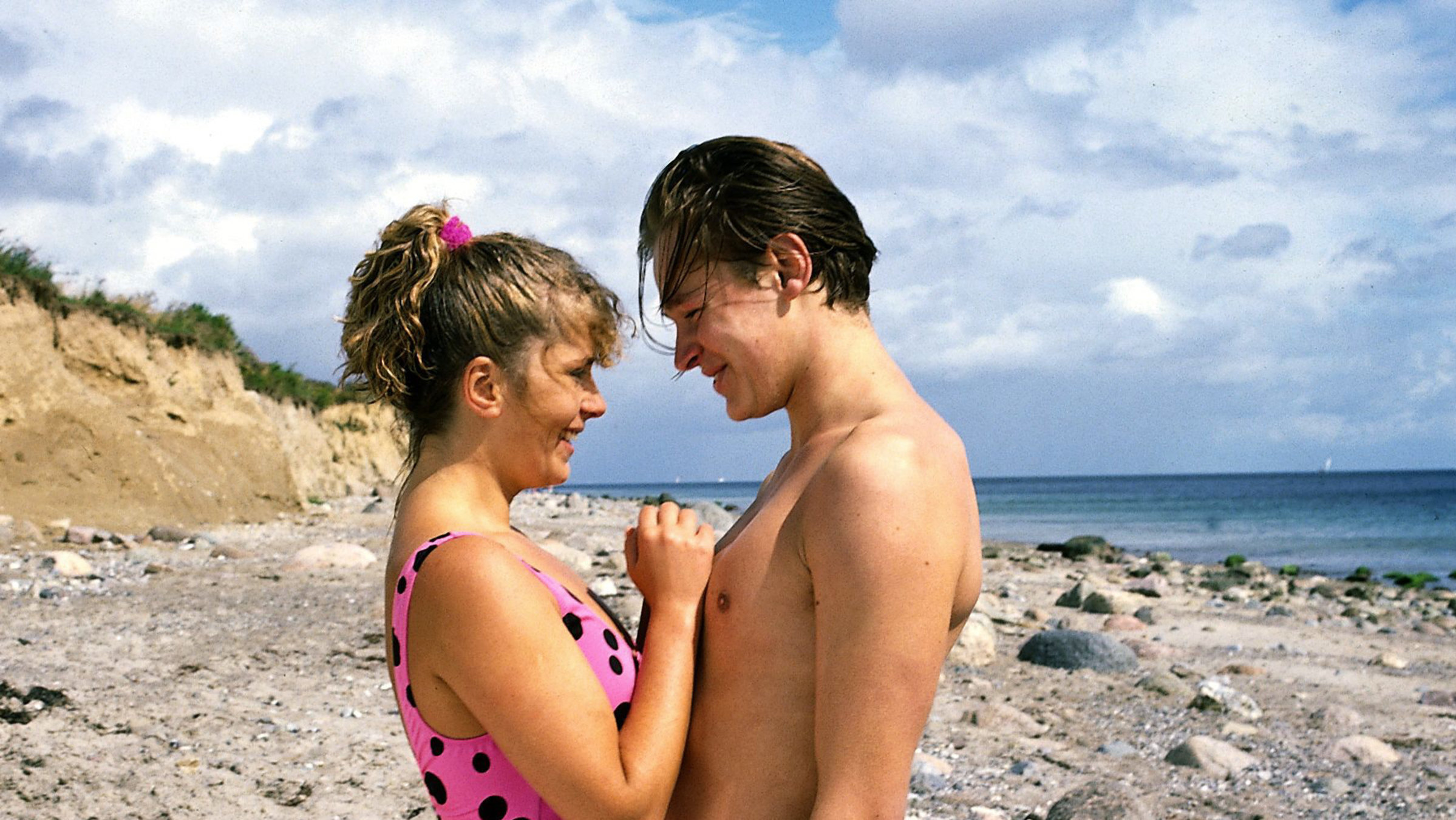 "Der Landarzt - Das Angebot": Eike (Hendrik Martz) und Vroni (Karin Thaler) stehen sich an einem Strand eng gegenüber und schauen sich inniglich an.