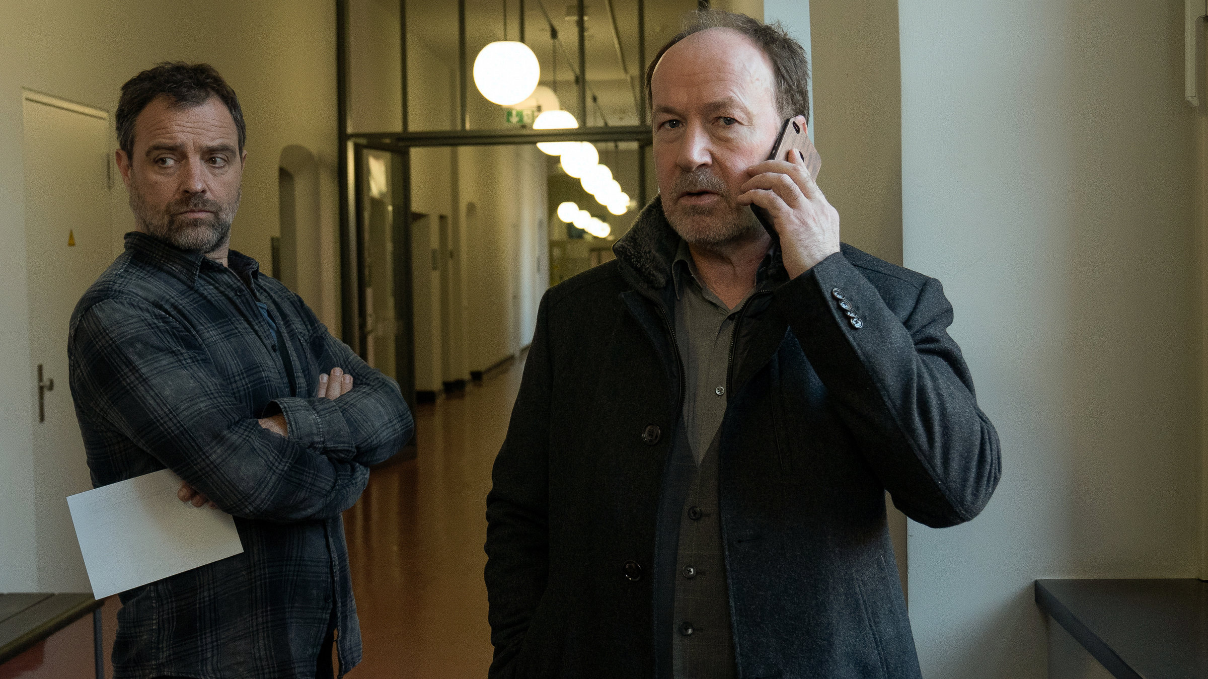 "Neben der Spur - Die andere Frau": Joe Jessen (Ulrich Noethen) steht mit Ruiz (Jürgen Maurer) auf einem Flur und telefoniert.