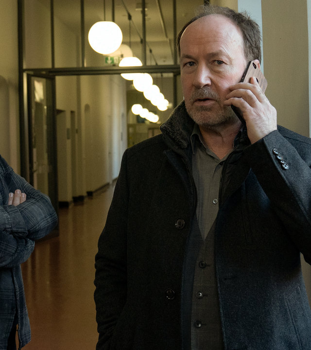 "Neben der Spur - Die andere Frau": Joe Jessen (Ulrich Noethen) steht mit Ruiz (Jürgen Maurer) auf einem Flur und telefoniert.
