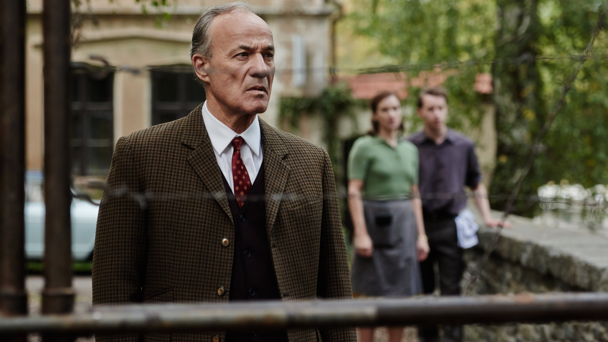 "TANNBACH - Schicksal eines Dorfes (5): Frieden aus Stein": Georg von Striesow (Heiner Lauterbach) steht auf einer kleinen Steinbrücke und blickt fassungslos auf den Stacheldraht-Zaun vor sich.