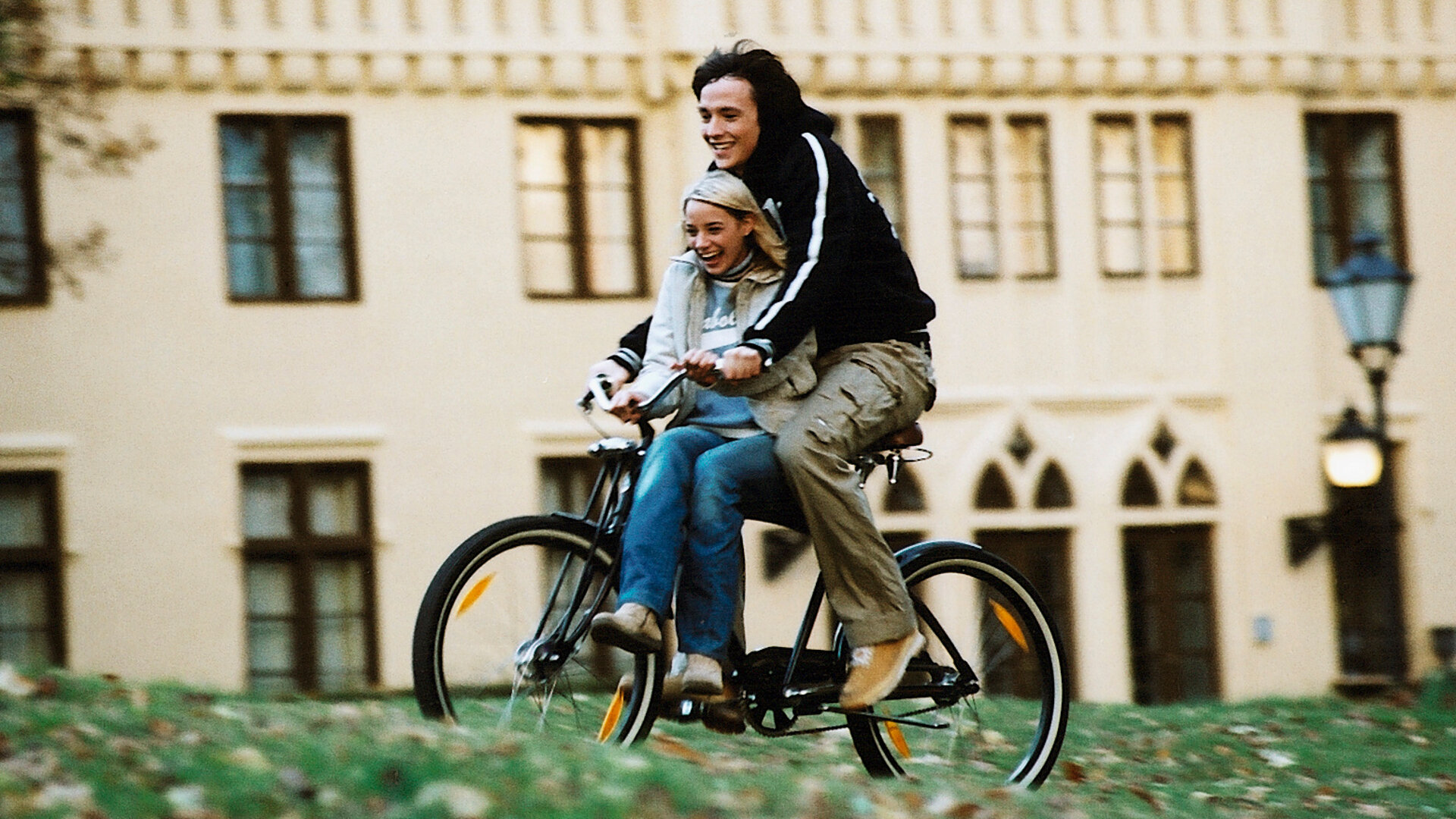 "Bianca - Wege zum Glück: Folge 65": Vor dem Gutshof: Sofia (Jytte-Merle Böhrnsen) sitzt vorne auf dem Fahrrad. Heiko (Ralph Kretschmar) fährt das Fahrrad. Sie lachen beide und scheinen Spaß zu haben.