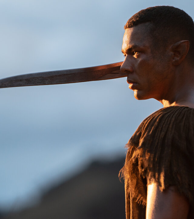 "Der Herr der Ringe: Die Ringe der Macht - Die Große Woge": Arondir (Ismael Cruz Córdova) steht im Freien. Er hält einen langen Dolch in der rechten Hand.