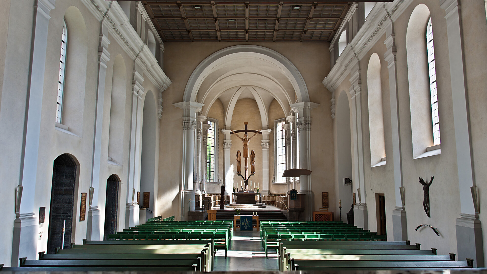 "Evangelischer Gottesdienst - Wie ertragen wir einander?": Blick in den Innenraum einer Kirche: Durch hohe, schlanke Fenster fÃ¤llt das Licht auf die weiÃen InnenwÃ¤nde der Kirche, deren einziger Schmuck die kunstvoll mit Stuck dekorierten SÃ¤ulen sind. Im Altarraum befindet sich eine Kreuzigungsgruppe aus Lindenholz.