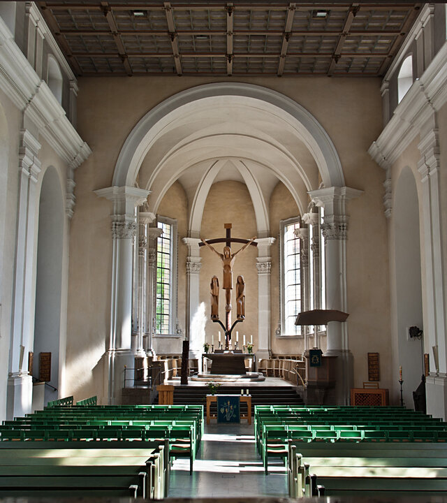"Evangelischer Gottesdienst - Wie ertragen wir einander?": Blick in den Innenraum einer Kirche: Durch hohe, schlanke Fenster fÃ¤llt das Licht auf die weiÃen InnenwÃ¤nde der Kirche, deren einziger Schmuck die kunstvoll mit Stuck dekorierten SÃ¤ulen sind. Im Altarraum befindet sich eine Kreuzigungsgruppe aus Lindenholz.