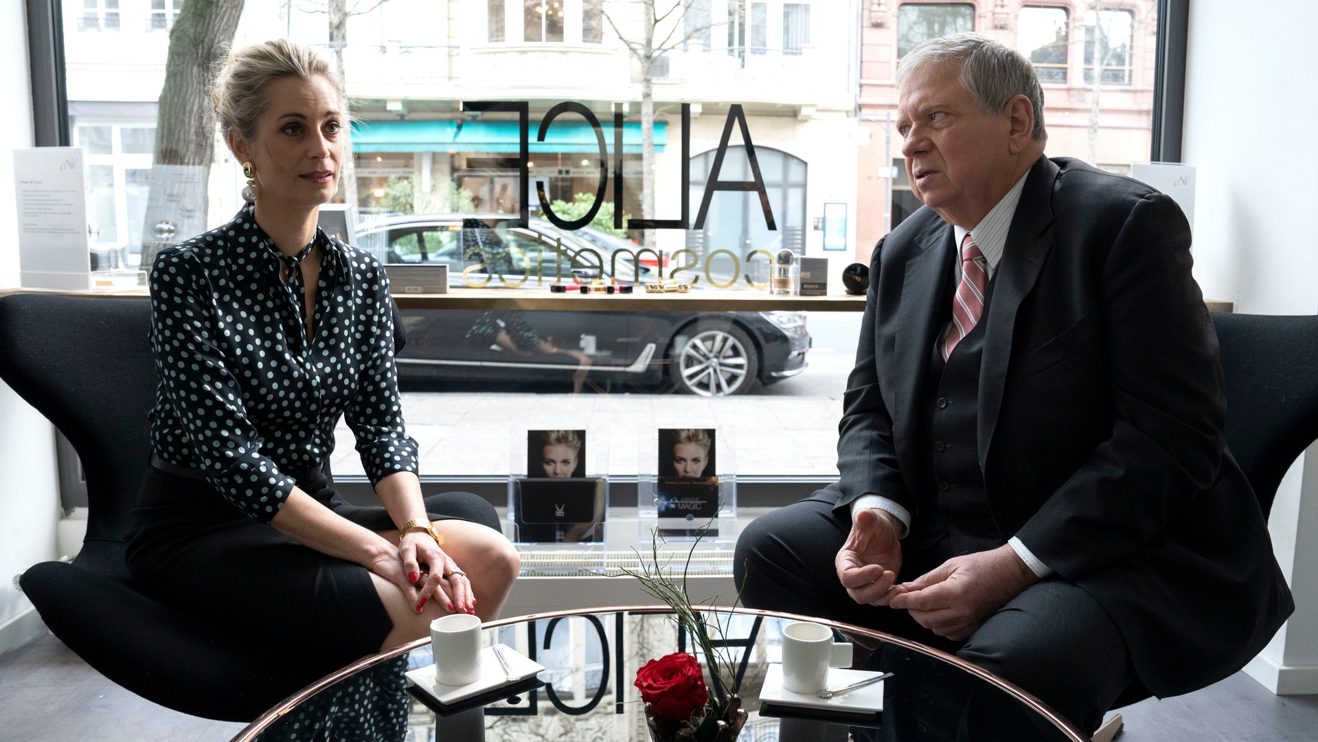 "Der Staatsanwalt - Rot wie Blut": Alice Berger (Tina Bordihn) und Bernd Reuther (Rainer Hunold) sitzen an einem Glastisch. Alice sieht ins Leere, während Reuter sie anschaut.