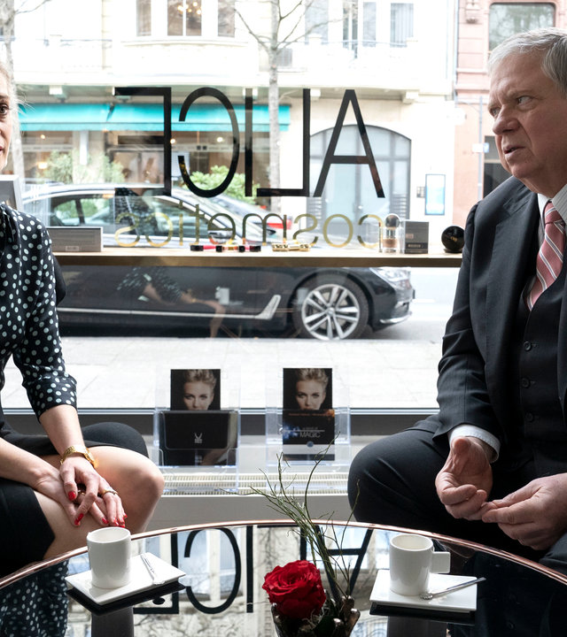 "Der Staatsanwalt - Rot wie Blut": Alice Berger (Tina Bordihn) und Bernd Reuther (Rainer Hunold) sitzen an einem Glastisch. Alice sieht ins Leere, während Reuter sie anschaut.