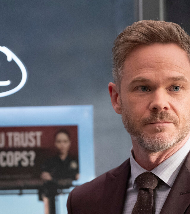 "The Rookie - Drei Billboards": Wesley Evers (Shawn Ashmore) steht vor einer Tafel, auf der ein großer Buchstabe, sowie verschiedene Stadteile verzeichnet sind. Außerdem ist ein Foto von einer großen Werbetafel darauf angebracht. Wesley blickt interessiert nach vorn.