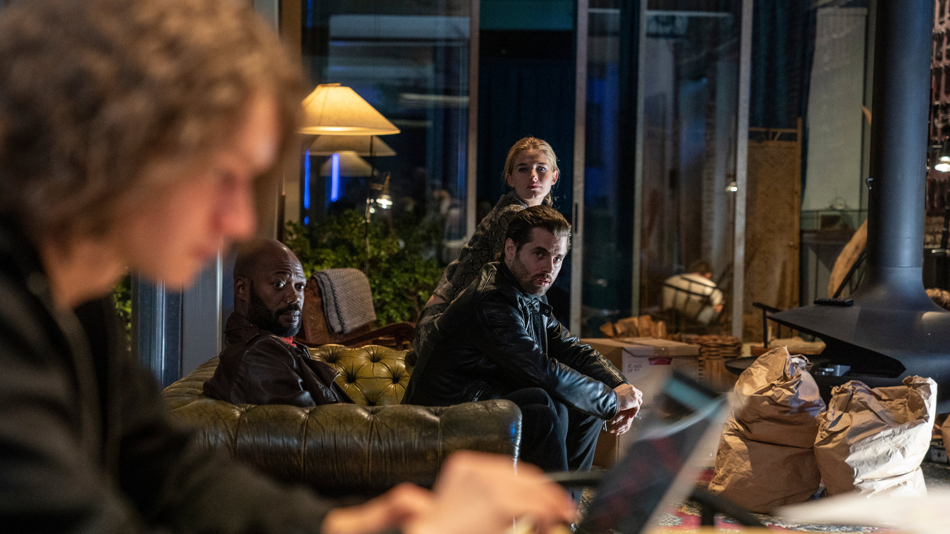 "The Bank Hacker": Jeremy (Tijmen Govaerts) sitzt vor einem Laptop, während Souleymane (Claude Musungayi), Ada (Ella-June Henrard) und Prince (Manuel Broekman) zu ihm blicken und ihn beobachten.